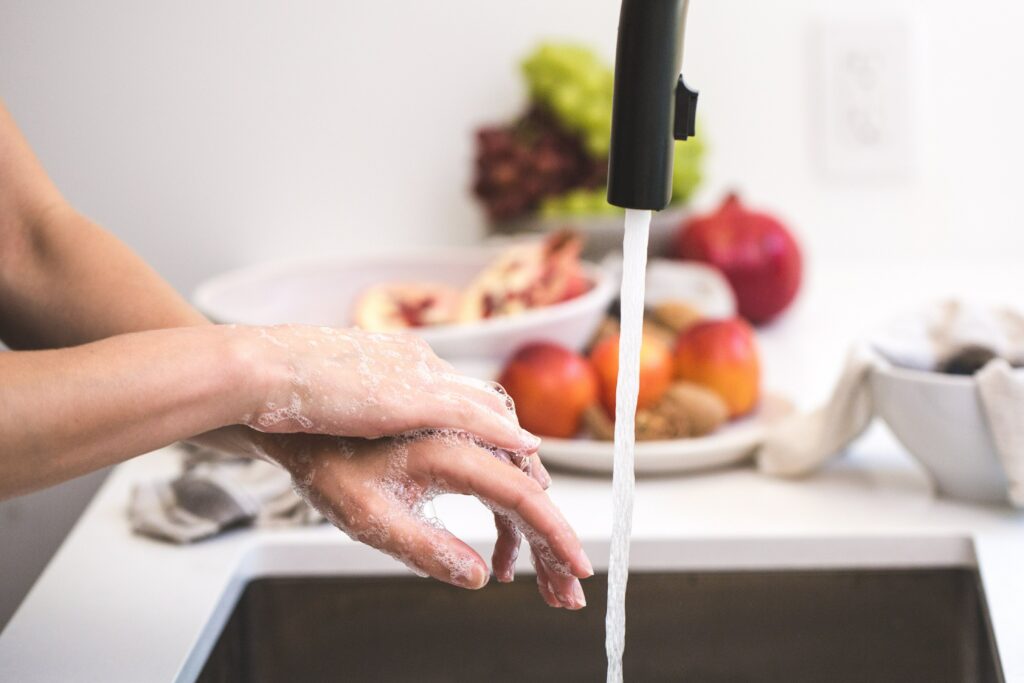 Person washing hands under running water